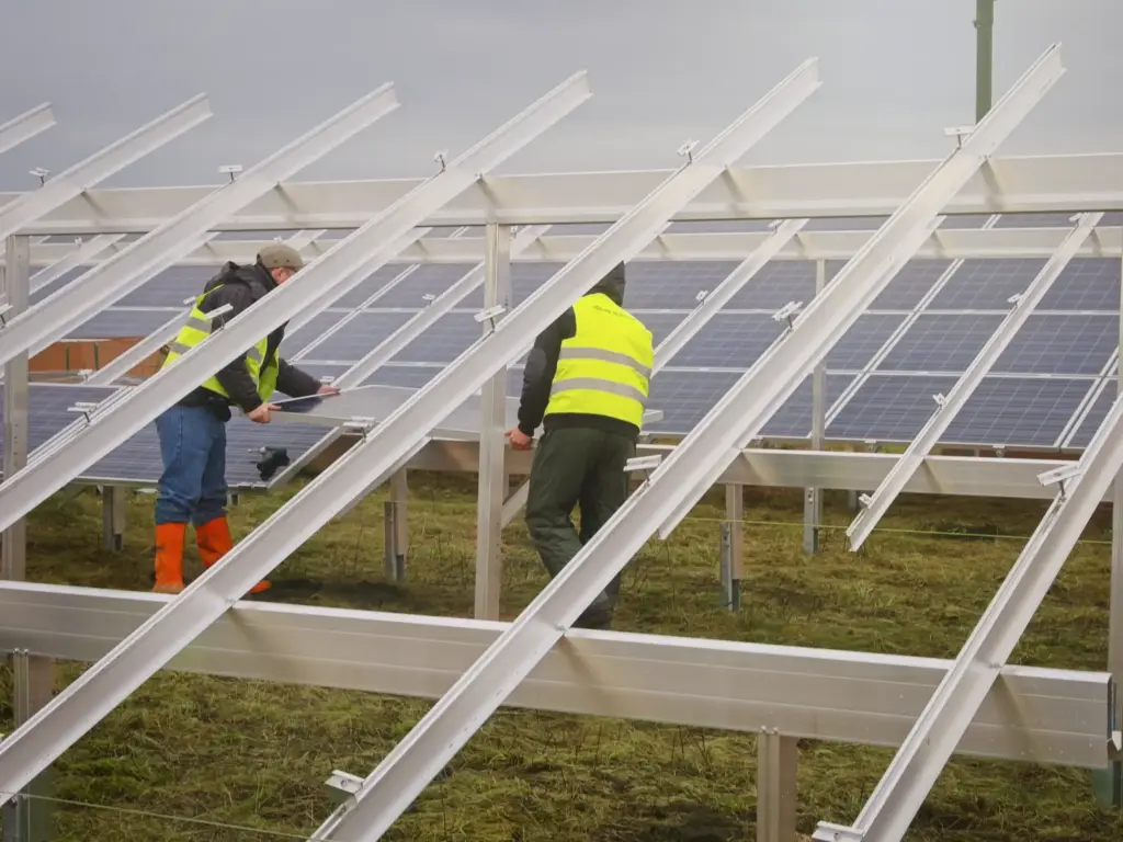 Das Montageteam positioniert und verschraubt die Photovoltaik-Module auf der Unterkonstruktion.