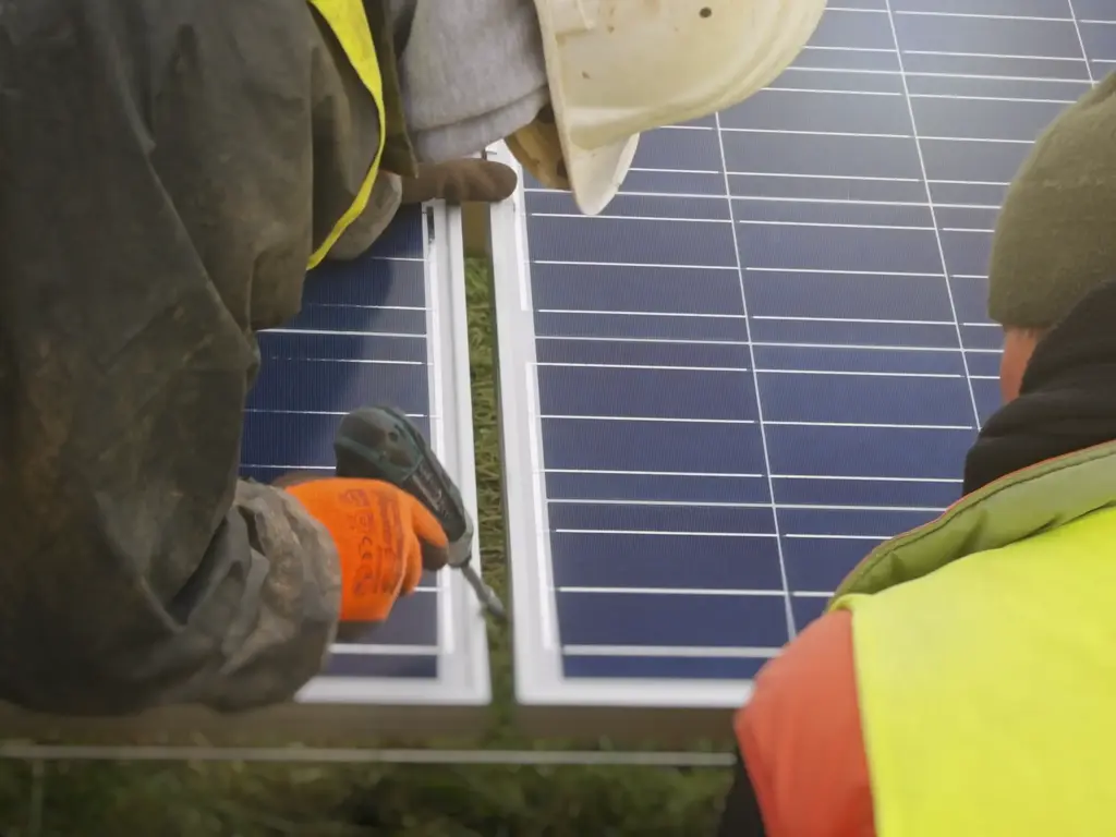 Techniker fixieren die Solarpaneele Schritt für Schritt auf den Aluminiumgestellen. 